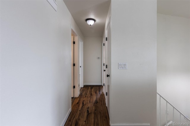 corridor with wood finished floors and baseboards