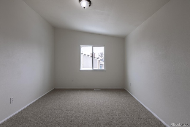 spare room featuring baseboards, vaulted ceiling, and carpet flooring