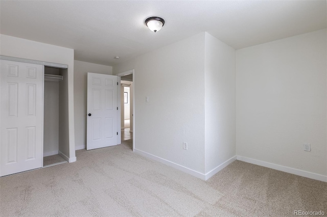 unfurnished bedroom with carpet floors, a closet, and baseboards