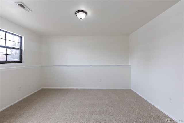 carpeted spare room with visible vents and baseboards