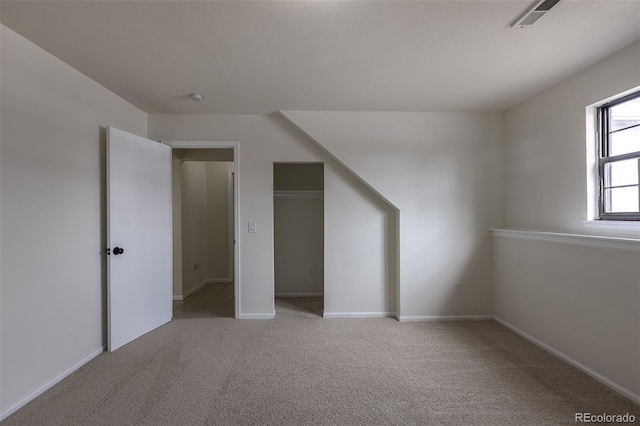 additional living space featuring carpet, visible vents, and baseboards