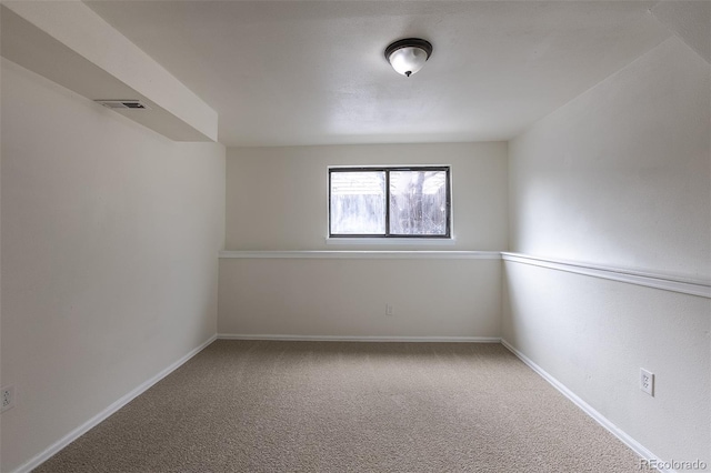 unfurnished room with carpet floors, visible vents, and baseboards