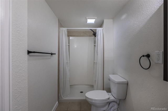 bathroom with a textured wall, tile patterned flooring, toilet, and a shower stall