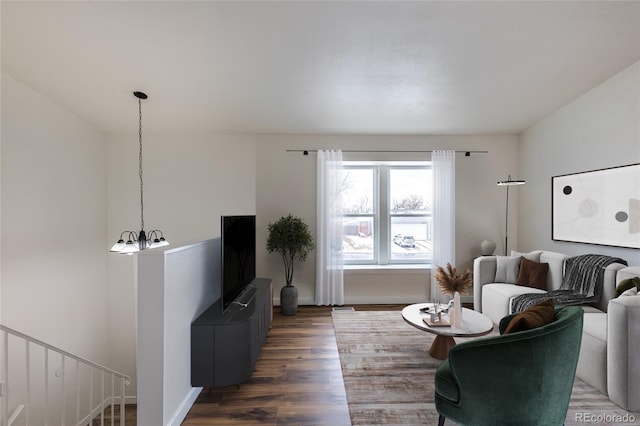 living area with a notable chandelier, baseboards, and wood finished floors