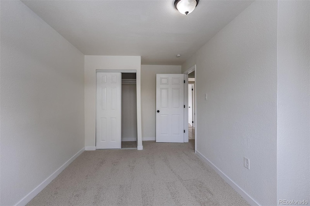 unfurnished bedroom with carpet floors, baseboards, and a closet