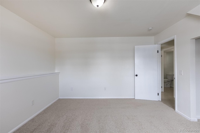 unfurnished room with carpet and baseboards