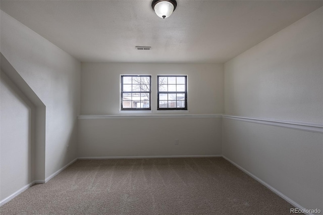 carpeted empty room featuring visible vents and baseboards