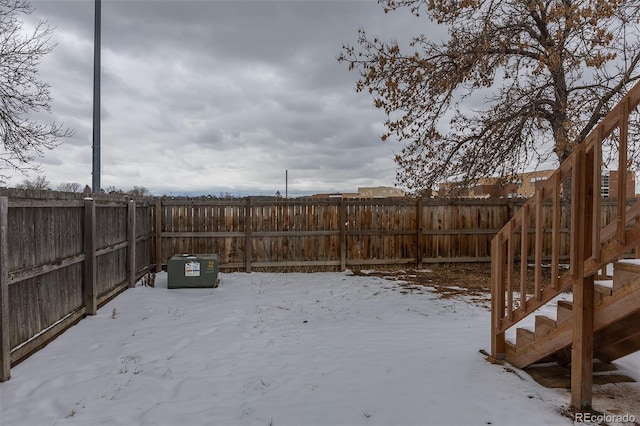 snowy yard with a fenced backyard