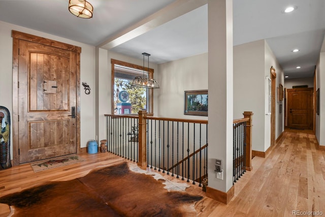 entrance foyer with baseboards, a chandelier, light wood-style flooring, and recessed lighting