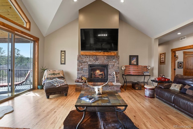 living room with lofted ceiling, recessed lighting, a fireplace, wood finished floors, and visible vents