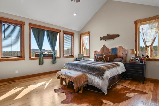 bedroom with high vaulted ceiling, baseboards, visible vents, and wood finished floors