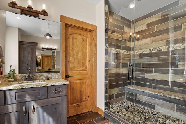 full bath with a stall shower and vanity