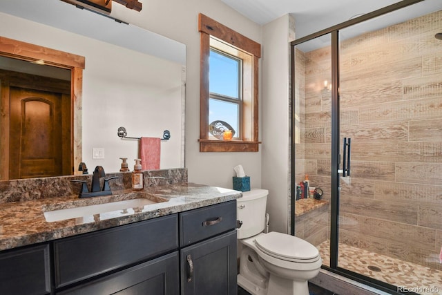 full bath featuring a shower stall, toilet, and vanity