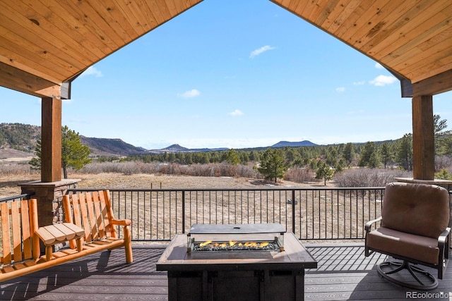 wooden deck with a mountain view and a fire pit