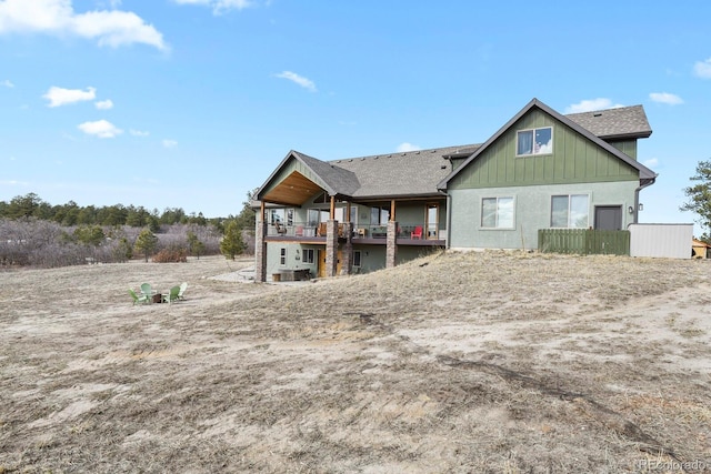 rear view of property featuring a shingled roof and board and batten siding