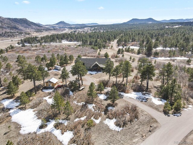 birds eye view of property featuring a forest view and a mountain view