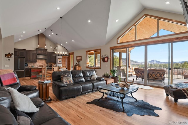5800 Elk View Ct, Larkspur, CO 80118 - living area featuring high vaulted ceiling, a mountain view, light wood-style flooring, a chandelier, and recessed lighting