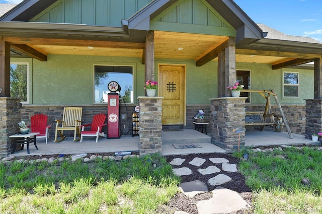 5800 Elk View Ct, Larkspur, CO 80118 - property entrance featuring a porch, board and batten siding, stucco siding, and stone siding