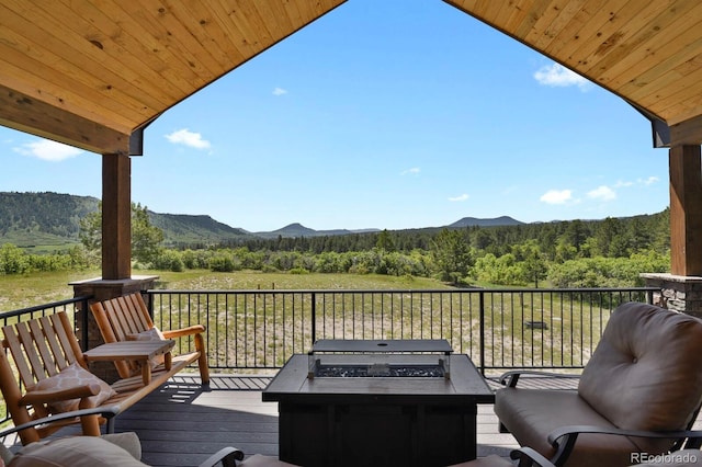 5800 Elk View Ct, Larkspur, CO 80118 - wooden deck featuring an outdoor fire pit, a view of trees, a mountain view, and a grill
