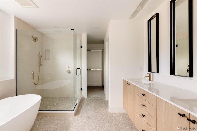 full bathroom featuring baseboards, double vanity, a freestanding tub, a sink, and a shower stall