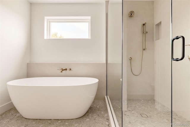 bathroom featuring a freestanding bath and a shower stall