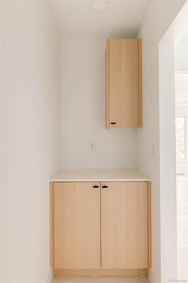 bar with light brown cabinetry