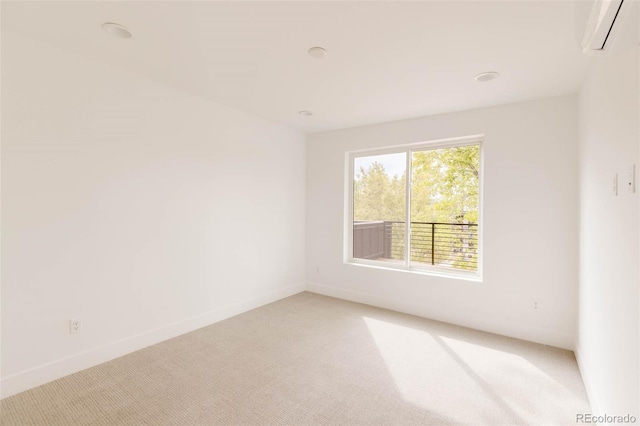 spare room with baseboards, light carpet, and an AC wall unit