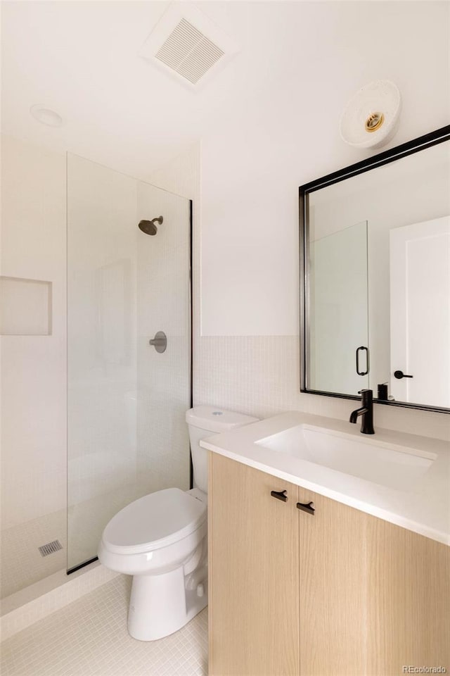 bathroom featuring vanity, visible vents, tile patterned flooring, walk in shower, and toilet