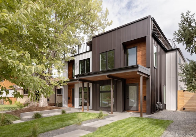 contemporary home featuring board and batten siding and a front yard