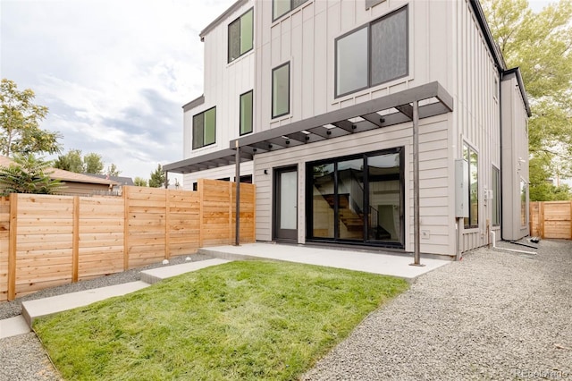 rear view of house featuring a yard and a patio