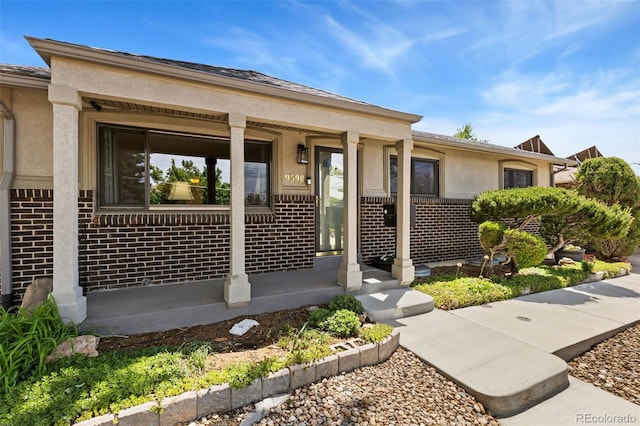 9598 Lowell Blvd, Westminster, CO 80031 - view of front of home featuring brick siding, a porch, and stucco siding
