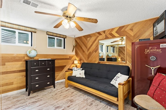 9598 Lowell Blvd, Westminster, CO 80031 - sitting room featuring a ceiling fan, wooden walls, a textured ceiling, and wood finished floors