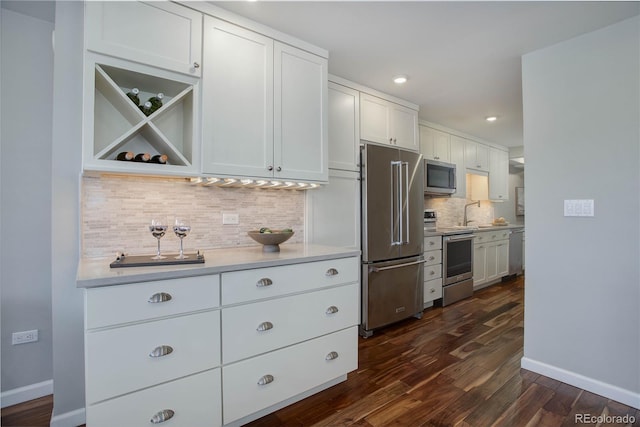 909 N Logan St Unit 1B, Denver, CO 80203 - kitchen featuring stainless steel appliances, tasteful backsplash, dark wood-style floors, light countertops, and white cabinetry