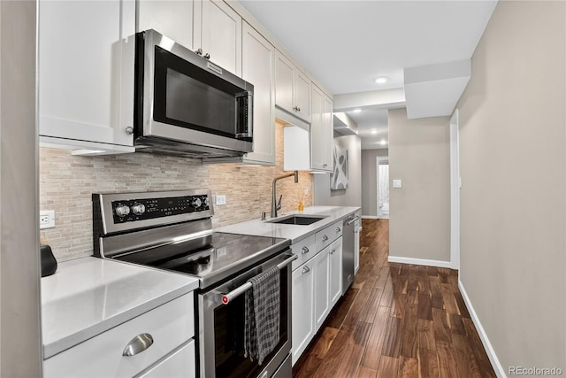 909 N Logan St Unit 1B, Denver, CO 80203 - kitchen featuring stainless steel appliances, dark wood-style flooring, decorative backsplash, light countertops, and recessed lighting