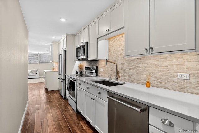 909 N Logan St Unit 1B, Denver, CO 80203 - kitchen with stainless steel appliances, light countertops, tasteful backsplash, dark wood finished floors, and recessed lighting