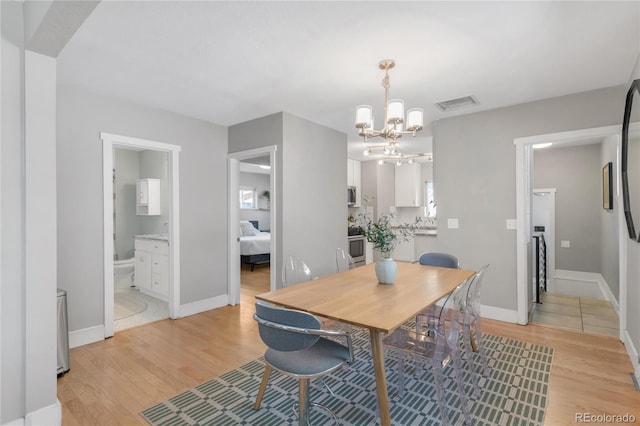 4933 Grove St, Denver, CO 80221 - dining room with a chandelier, light wood-style flooring, and baseboards