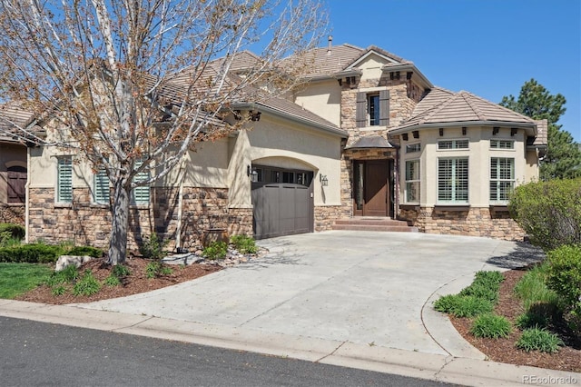 view of front of home with an attached garage, a tile roof, stone siding, stucco siding, and driveway