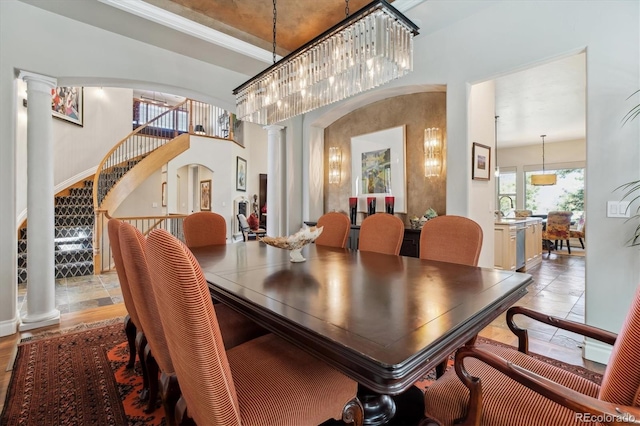 dining area featuring ornate columns, arched walkways, and stairway