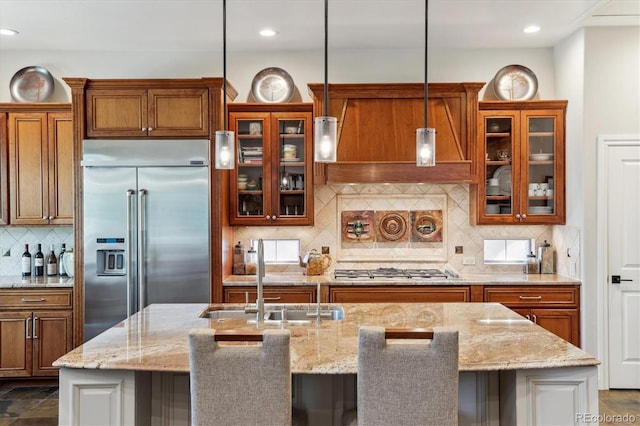 kitchen featuring brown cabinetry, backsplash, a sink, stainless steel appliances, and recessed lighting