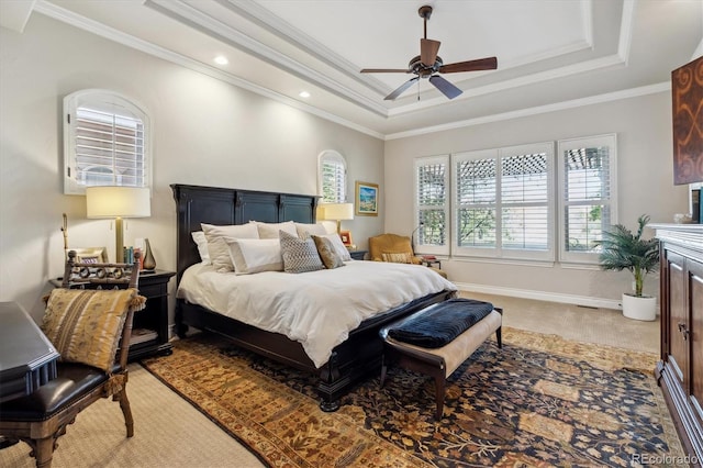bedroom with crown molding, a ceiling fan, a tray ceiling, and light carpet