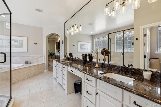 full bathroom featuring visible vents, double vanity, tile patterned floors, a shower stall, and a sink