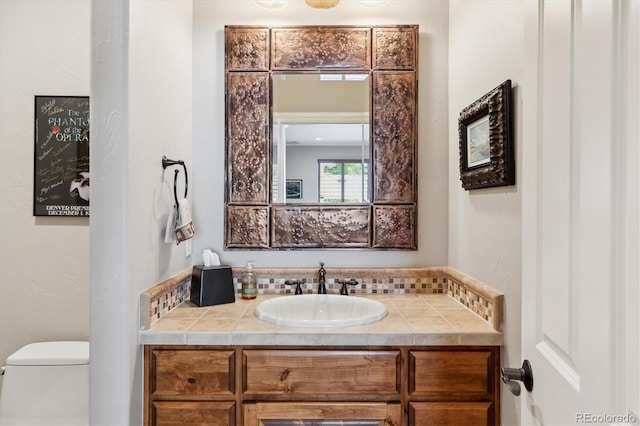 half bathroom featuring vanity and toilet
