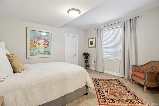 bedroom featuring baseboards and light carpet