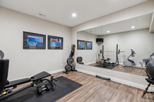 workout area featuring baseboards, recessed lighting, wood finished floors, and visible vents
