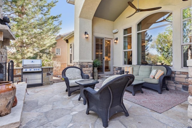 view of patio with area for grilling, an outdoor kitchen, a ceiling fan, and an outdoor hangout area