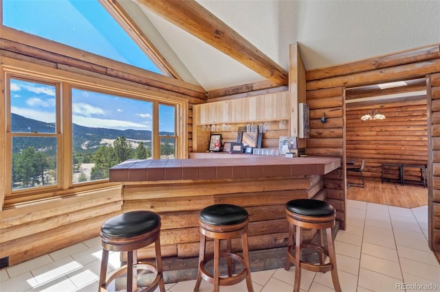 660 Wagon Wheel Rd, Guffey, CO 80820 - indoor dry bar featuring log walls, beam ceiling, a mountain view, high vaulted ceiling, and light tile patterned floors