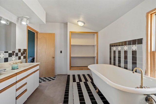 660 Wagon Wheel Rd, Guffey, CO 80820 - bathroom with double vanity, a freestanding bath, decorative backsplash, and vaulted ceiling