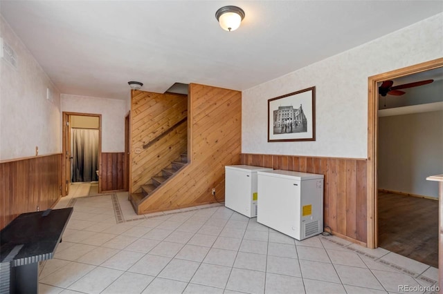 660 Wagon Wheel Rd, Guffey, CO 80820 - laundry area featuring wood walls, light tile patterned flooring, a wainscoted wall, washing machine and dryer, and ceiling fan