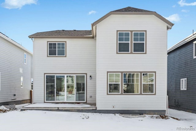 view of snow covered rear of property