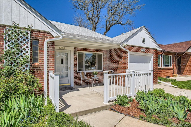 5703 Ammons St, Arvada, CO 80002 - view of front facade with a porch, brick siding, a shingled roof, and an attached garage